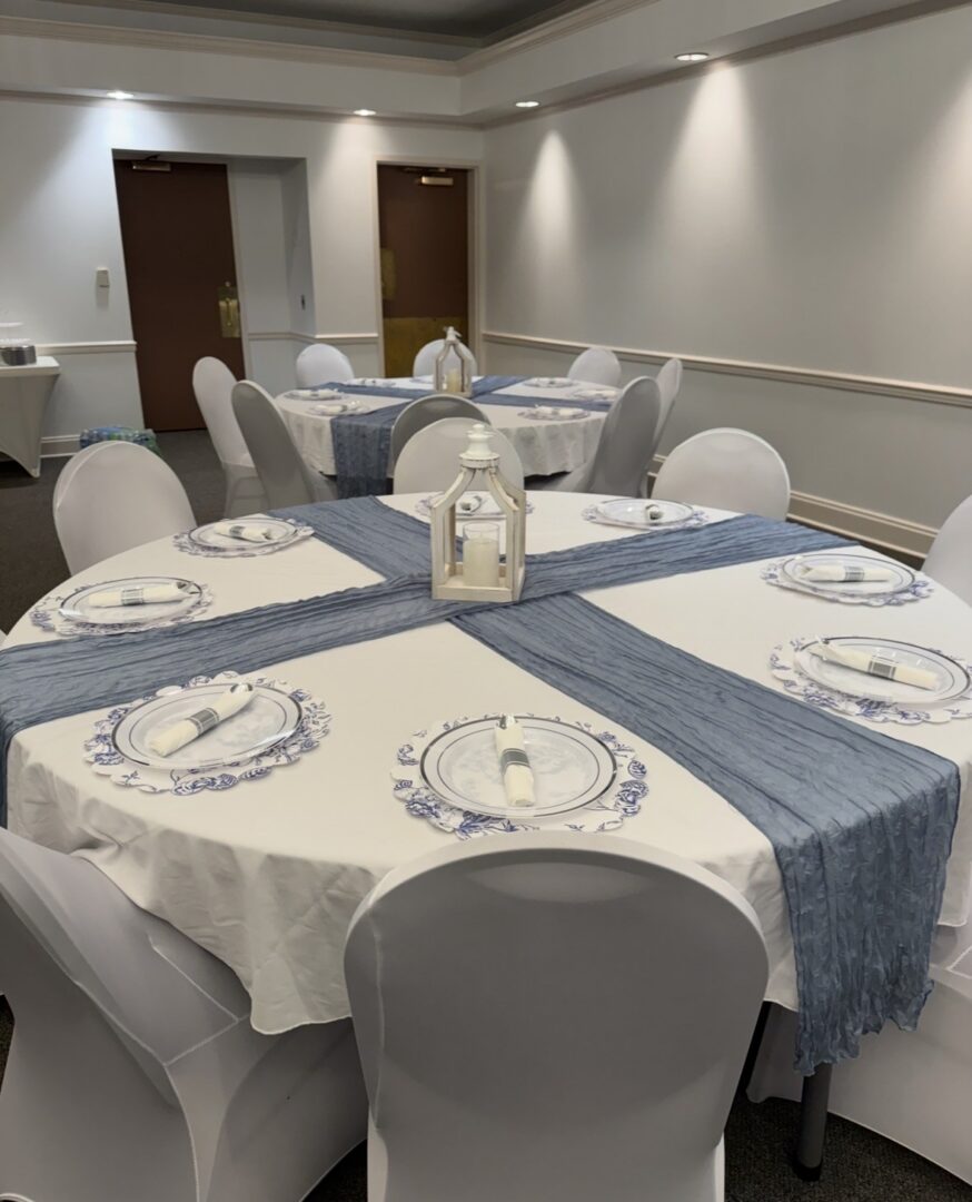 Round banquet tables set with blue runners